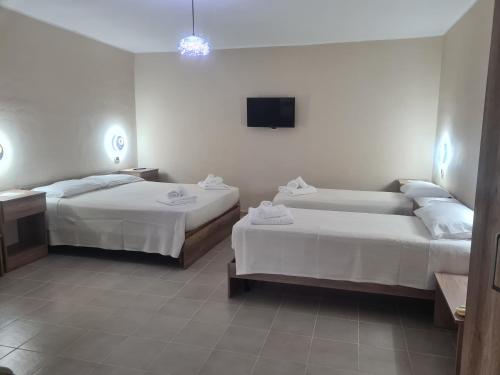 a hotel room with two beds and a flat screen tv at Agriturismo Cara Terra Lucana in Chiaromonte