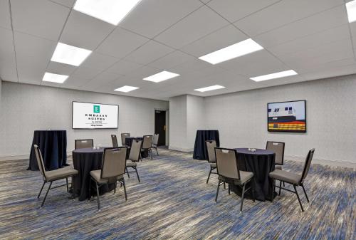 a conference room with tables and chairs and a screen at Embassy Suites Chicago - Downtown River North in Chicago