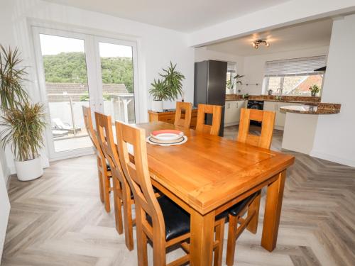 a kitchen and dining room with a wooden table and chairs at 4 Bodnant Road in Colwyn Bay