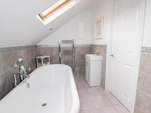 a bathroom with a white tub and a sink at 4 Bodnant Road in Colwyn Bay