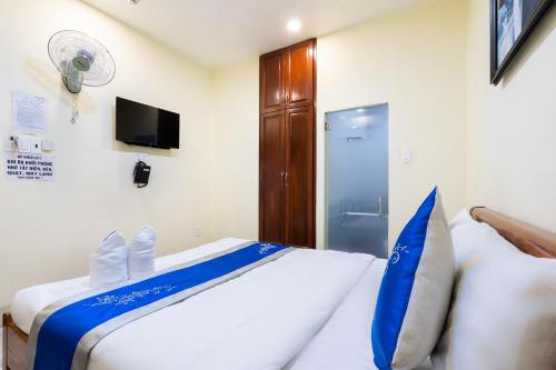 a bedroom with a bed with a blue and white blanket at Mai Phương - RUBY SAIGON HOTEL in Ho Chi Minh City