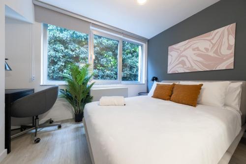 a bedroom with a large white bed and windows at Stella Stays Incredible 1 BDR Etiler in Istanbul