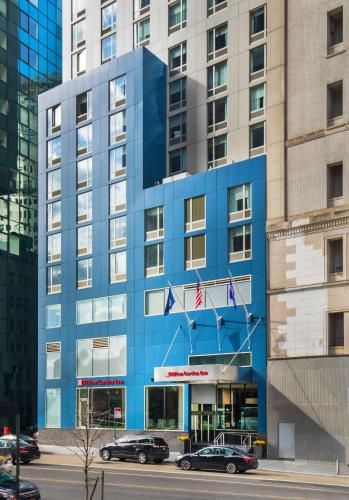 a blue building with cars parked in front of it at Hilton Garden Inn NYC Financial Center/Manhattan Downtown in New York