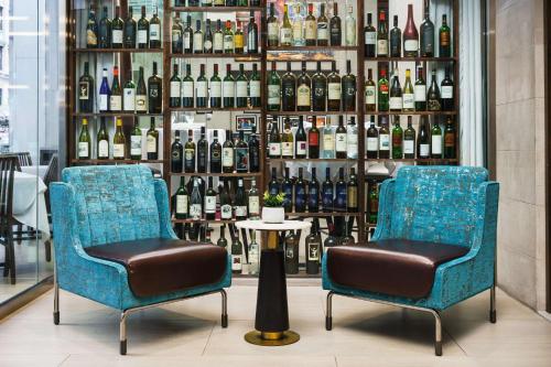 two chairs in front of a display of wine bottles at Hilton Garden Inn New York Times Square North in New York