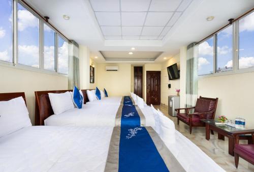 a hotel room with two beds with a blue carpet at Mai Phương - RUBY SAIGON HOTEL in Ho Chi Minh City