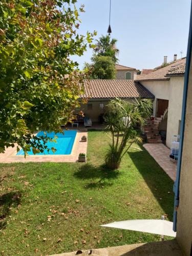 a view of a yard with a swimming pool at Entre vigne et Camargue in Générac