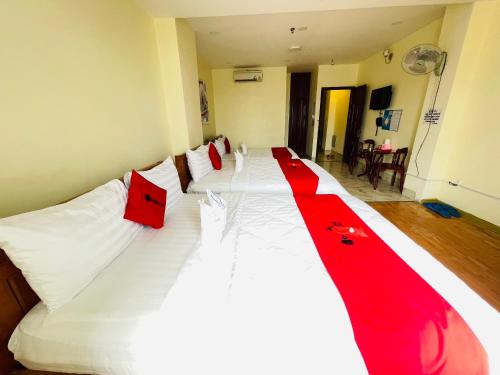 a large white bed with a red ribbon on it at Mai Phương - RUBY SAIGON HOTEL in Ho Chi Minh City
