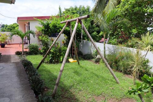 an old swing set in a yard with at Villa Bô Soley, côté Plages et Volcan in Le Prêcheur