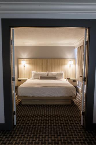 a bedroom with a large bed and two lamps at Century Plaza Hotel in Vancouver