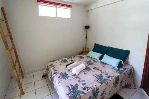a bedroom with a bed with blue pillows at Villa Bô Soley, côté Plages et Volcan in Le Prêcheur