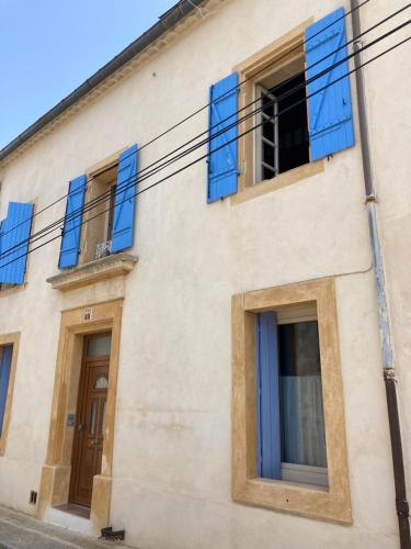 um edifício com persianas azuis em Entre vigne et Camargue em Générac