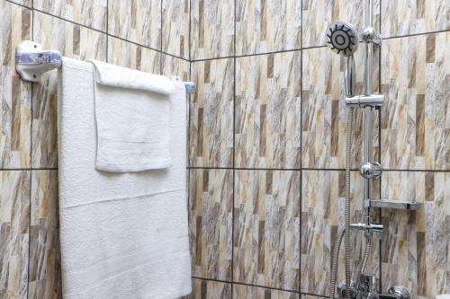 a bathroom with a shower with towels on a wall at Hôtel The Place in Yaoundé