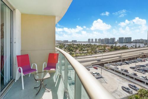 a balcony with two chairs and a view of a parking lot at ⌘Family Beach Home w Amazing Water Views - Upgraded Unit ⌘ in Miami Beach