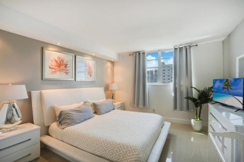 a bedroom with a white bed and a window at ⌘Family Beach Home w Amazing Water Views - Upgraded Unit ⌘ in Miami Beach