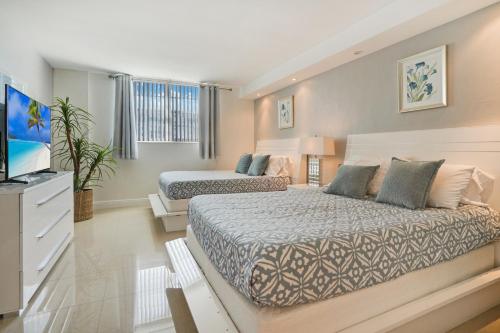 a bedroom with two beds and a flat screen tv at ⌘Family Beach Home w Amazing Water Views - Upgraded Unit ⌘ in Miami Beach