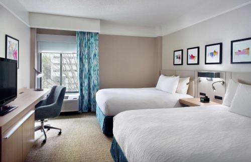 a hotel room with two beds and a flat screen tv at Hilton Garden Inn Atlanta-Buckhead in Atlanta
