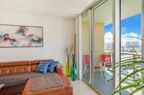 a living room with a leather couch and a balcony at ⌘Family Beach Home w Amazing Water Views - Upgraded Unit ⌘ in Miami Beach