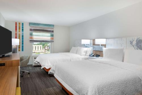 Hampton Inn & Suites Atlanta Buckhead Place في أتلانتا: غرفة فندقية بسريرين وتلفزيون بشاشة مسطحة