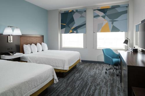 a hotel room with two beds and a desk at Hampton Inn & Suites Atlanta-Downtown in Atlanta