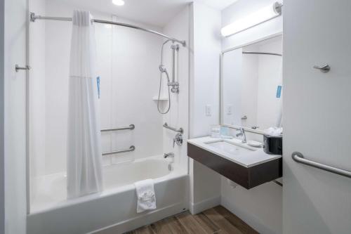 Hampton Inn & Suites Atlanta-Downtown في أتلانتا: حمام مع حوض ومغسلة ودش