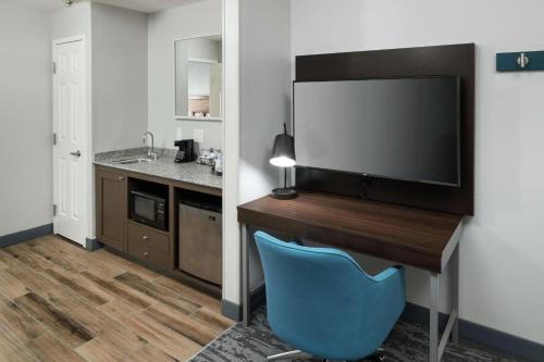 a room with a desk with a television and a blue chair at Hampton Inn & Suites Atlanta-Downtown in Atlanta