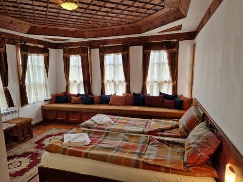 um quarto com uma cama e um sofá num quarto em Къща за гости Никула Чорбаджи em Zheravna