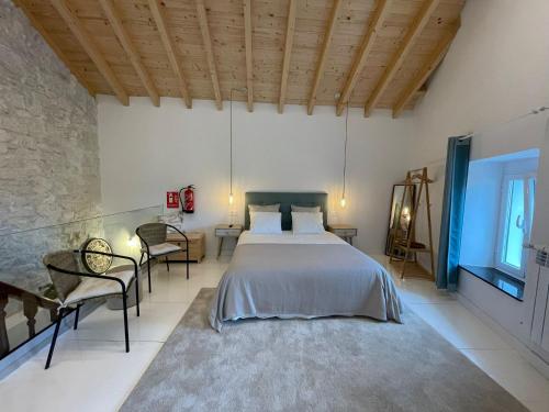 a bedroom with a bed and chairs in a room at Villa Tité in Oviedo