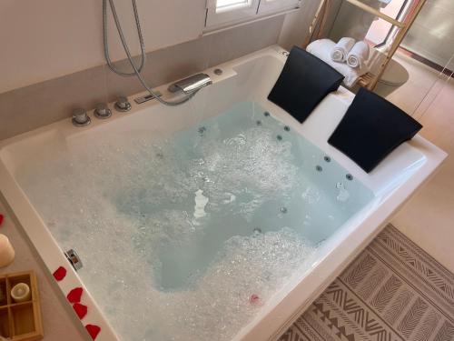 a bath tub filled with water in a bathroom at Villa Tité in Oviedo