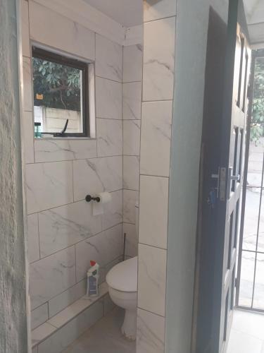 a bathroom with a toilet and a window at Comfort place 3 in Pretoria