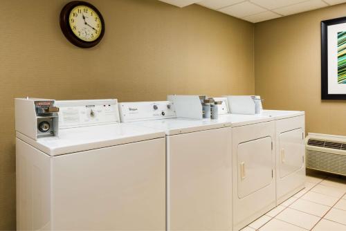 een wasmachine en droger in een kamer met een klok bij Homewood Suites by Hilton Birmingham South Inverness in Hoover
