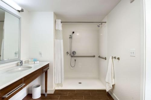 a white bathroom with a shower and a sink at Hampton Inn and Suites Clearwater Beach in Clearwater Beach