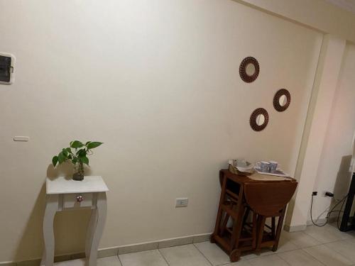 a white wall with a table and a clock on it at Dpto Centrico cerca de hospital escuela y facultad de medicina in Corrientes