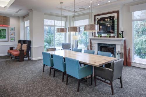 a dining room with a wooden table and blue chairs at Hilton Garden Inn Hilton Head in Hilton Head Island