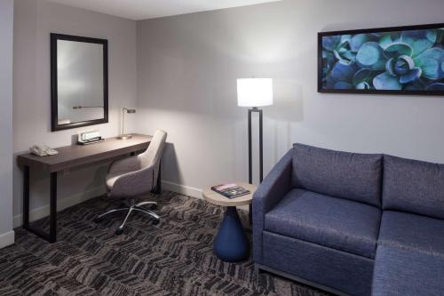 a hotel room with a couch and a desk and a chair at Hilton Garden Inn Hilton Head in Hilton Head Island