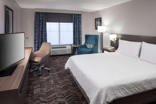 a hotel room with a bed and a flat screen tv at Hilton Garden Inn Hilton Head in Hilton Head Island