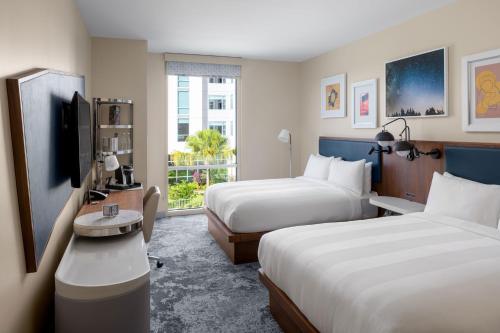 a hotel room with two beds and a tv at The Celeste Hotel, Orlando, a Tribute Portfolio Hotel in Orlando