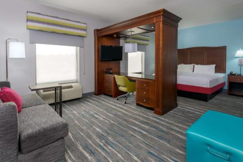 um quarto de hotel com uma cama e um sofá em Hampton Inn & Suites Winston-Salem/University Area em Winston-Salem