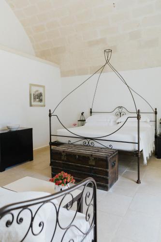 a bedroom with two beds and a canopy bed at Masseria Montelauro in Otranto