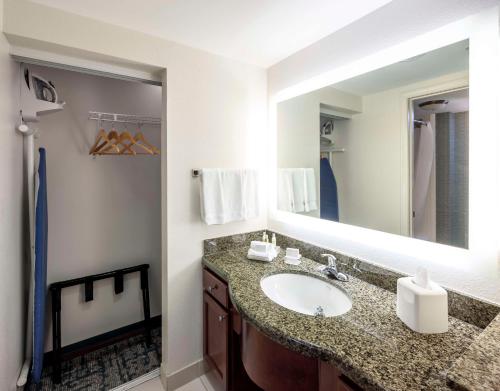 傑克孫維的住宿－南傑克遜維爾/聖約翰斯中心希爾頓惠庭套房酒店，一间带水槽和大镜子的浴室
