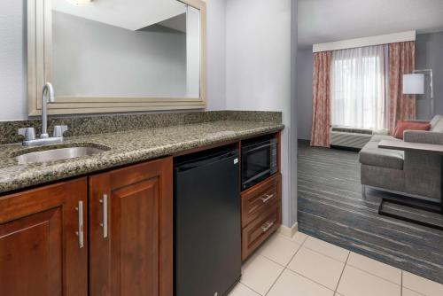 a kitchen with a sink and a counter top at Hampton Inn & Suites Orlando Airport at Gateway Village in Orlando