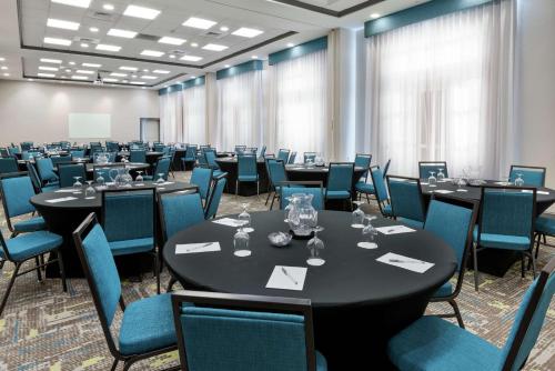 a conference room with tables and chairs in a room at Hampton Inn & Suites Orlando Airport at Gateway Village in Orlando