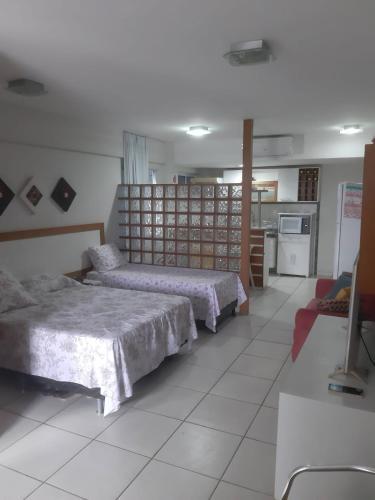 a room with two beds and a kitchen at Terrazzo PontaNegra flat Flat Vista Mar Apto 201 in Natal