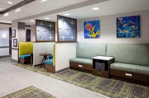a waiting room with green chairs and a table at Hampton Inn & Suites Mobile I-65@ Airport Boulevard in Mobile