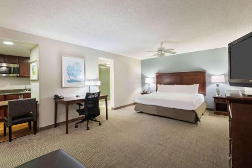 Homewood Suites by Hilton Tampa Airport - Westshore في تامبا: غرفة نوم مع سرير ومكتب مع جهاز كمبيوتر