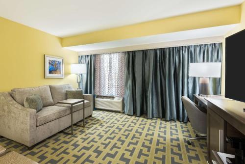 a living room with a couch and a desk at Hampton Inn & Suites Tampa Airport Avion Park Westshore in Tampa