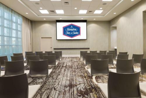 a conference room with chairs and a projection screen at Hampton Inn & Suites Tampa Airport Avion Park Westshore in Tampa