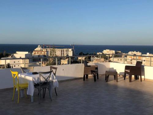 a table and chairs on the roof of a building at Résidence le corail de chat meriem in Sousse