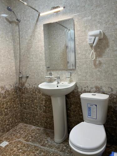 a bathroom with a toilet and a sink and a mirror at Asia Minor in Samarkand