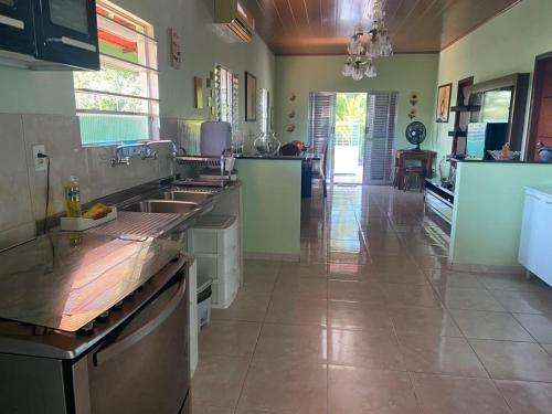 a large kitchen with stainless steel appliances and a tile floor at Residencial das Cachoeiras in Presidente Figueiredo