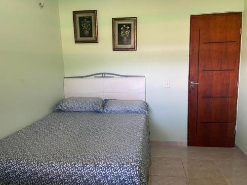 a bedroom with a bed and a wooden door at Residencial das Cachoeiras in Presidente Figueiredo